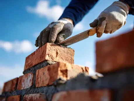 Mason rebuilding a fire-damaged chimney top in Somis